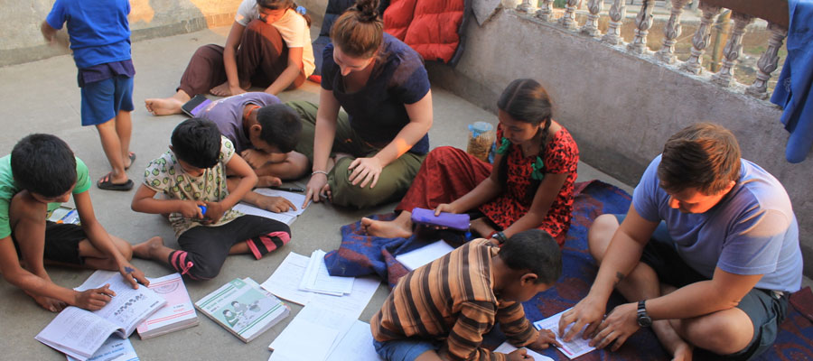 volunteers teaching children in orphanage